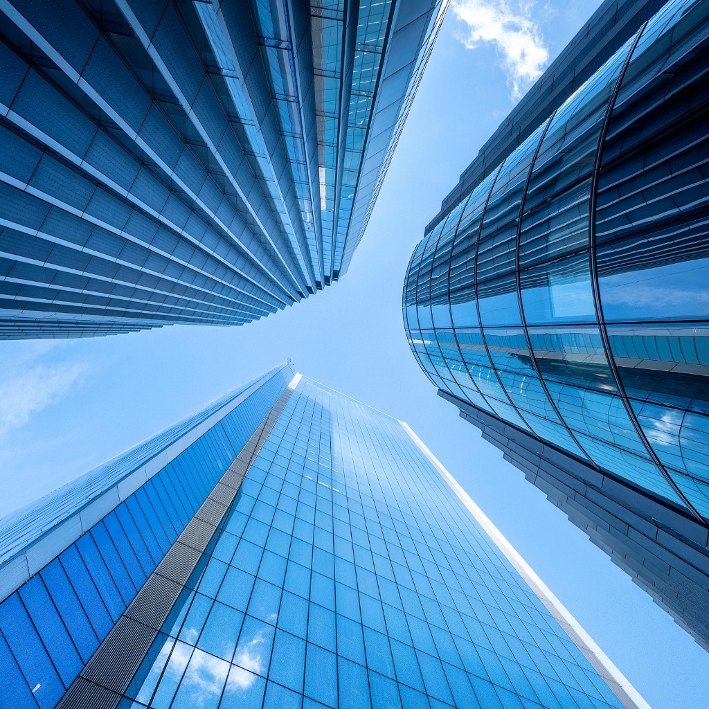 Glass towers viewed from below against a clear sky